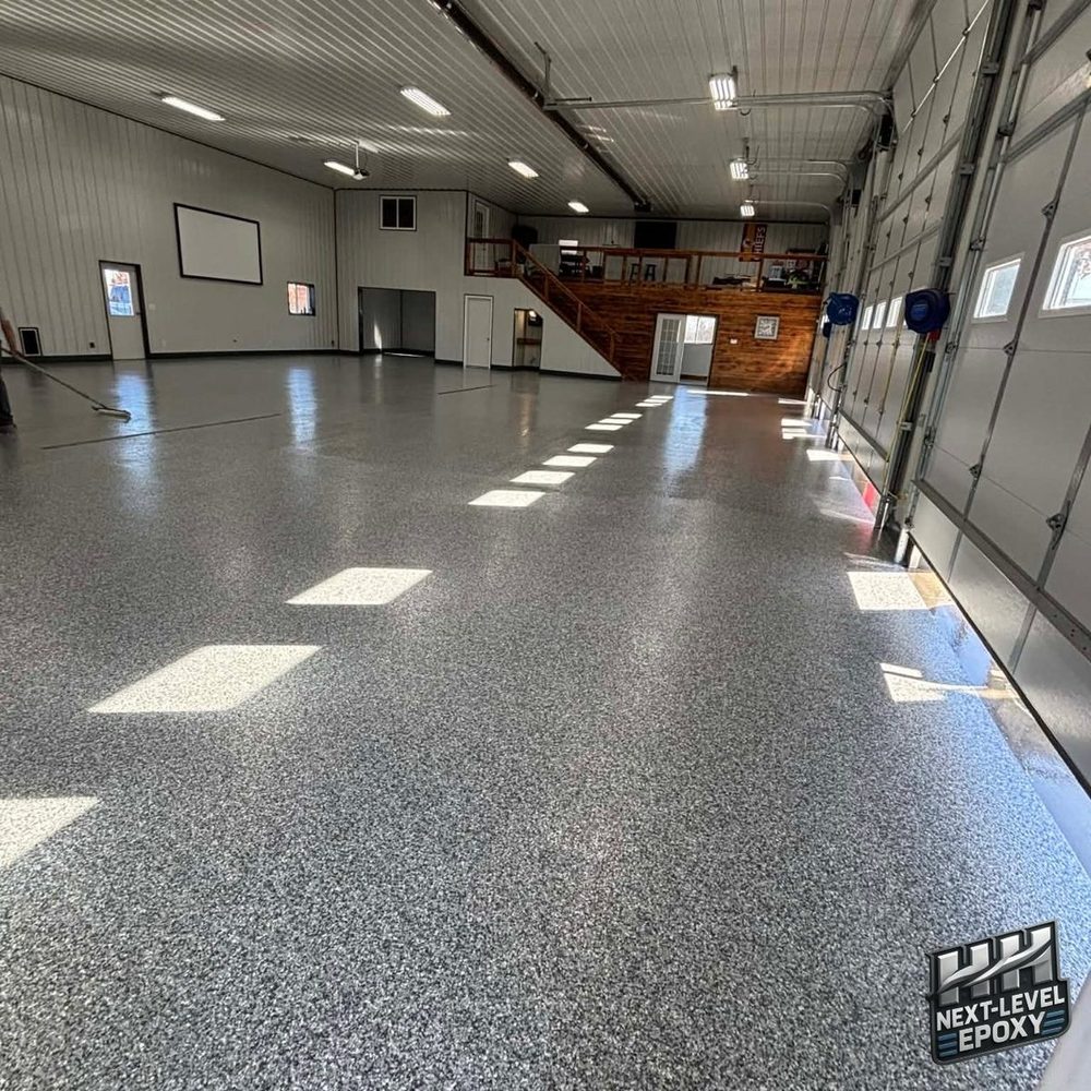 Pouring epoxy base coat on concrete floor during installation Kansas City