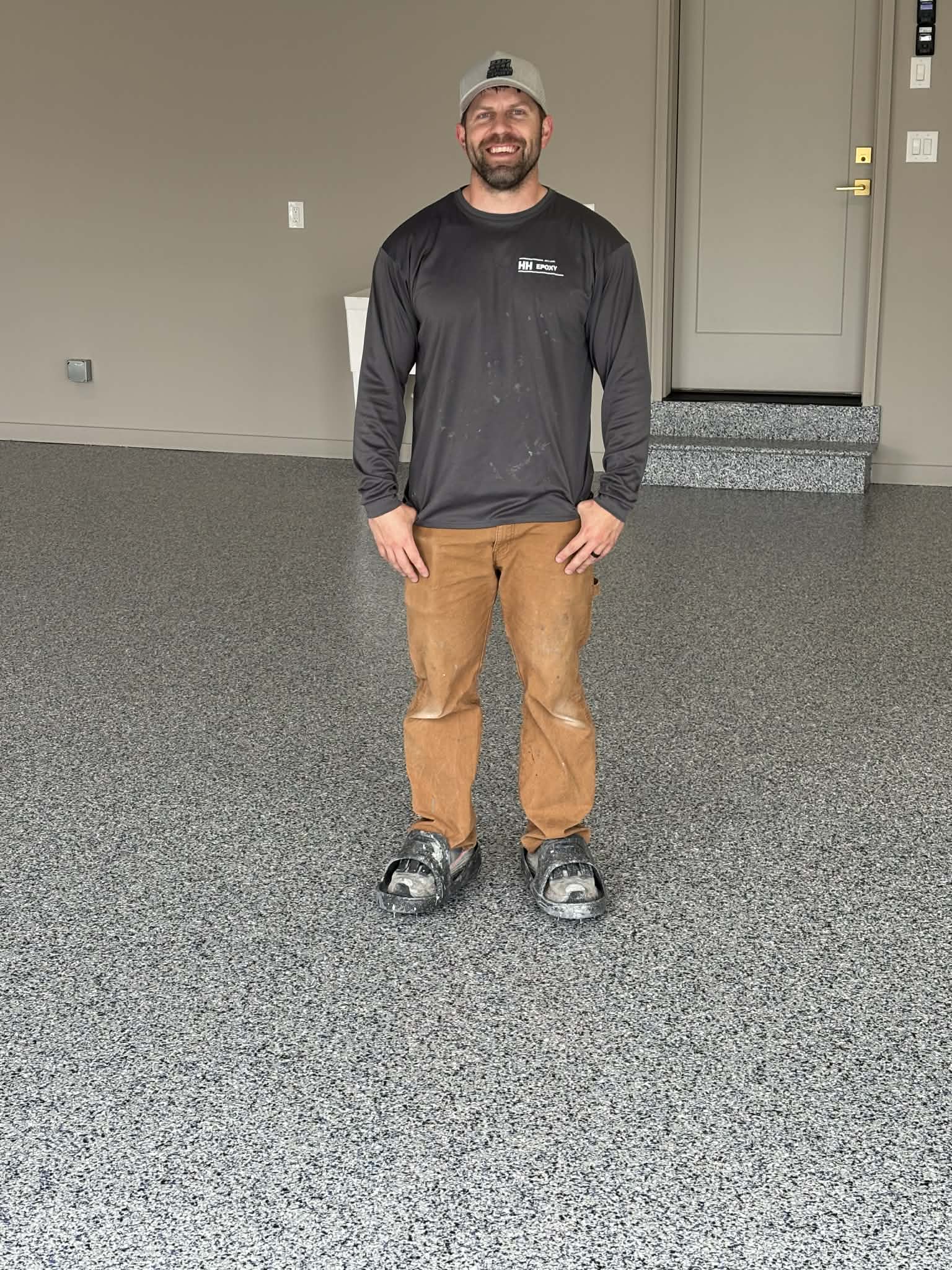 HH Next-Level Epoxy installer standing on completed epoxy garage floor Kansas City Missouri